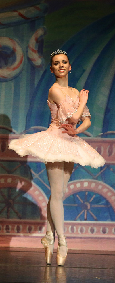 an image of a woman performer twirling in a white dress and smiling